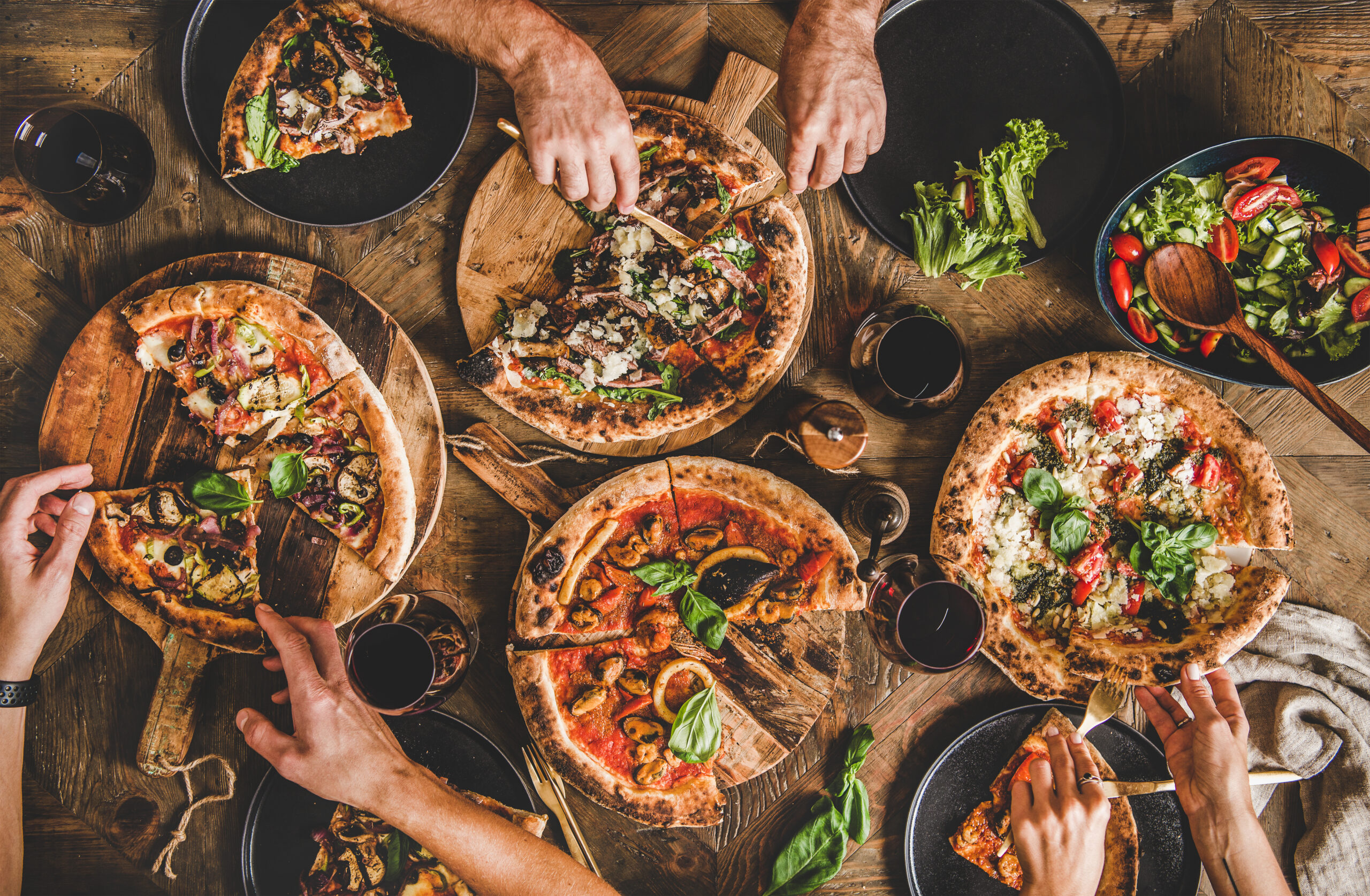 Group of People Eating Pizza with Various Drinks